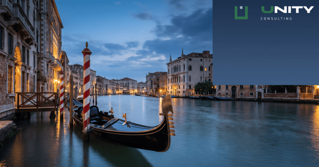 A gondola moored in a Venetian canal at blue hour, with historic buildings lining the water.