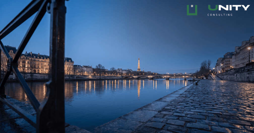 A wide-angle, deep focus photograph of the River Seine in Paris at blue hour, with the Eiffel Tower in the distance.